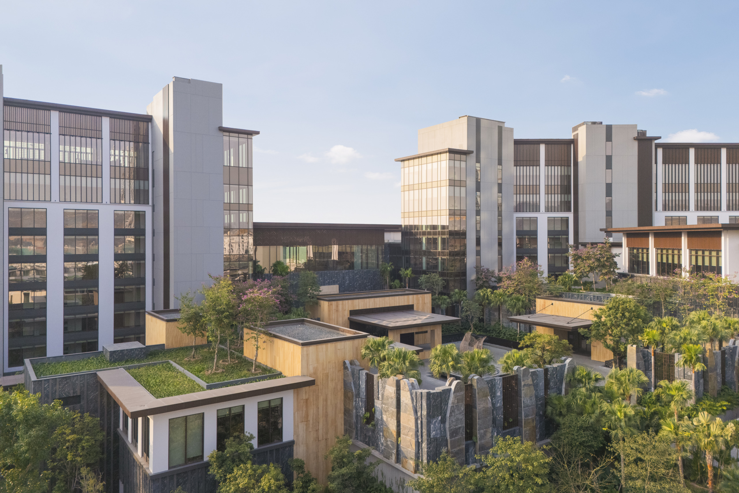Aerial drone view of the resort's mid-rise accommodation wing with green roofscape and surrounding tropical vegetation, InterContinental Halong Bay by WATG