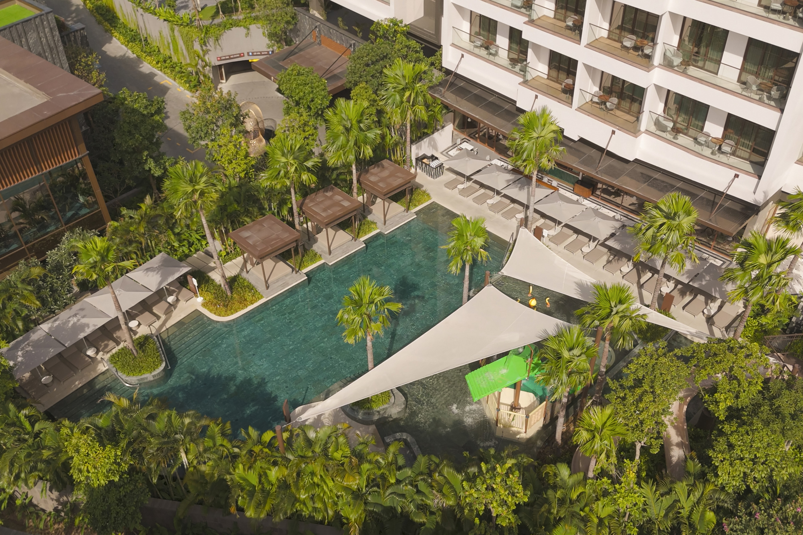 Aerial view of the resort's lagoon pool, beach club, and low-rise accommodation wings set within tropical gardens at InterContinental Halong Bay, by WATG