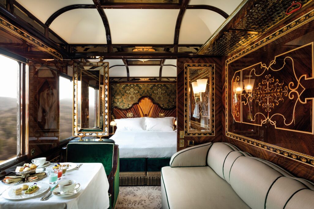 Curved headboard king sized bed and lush carpeted flooring with a touch European gold and emerald design