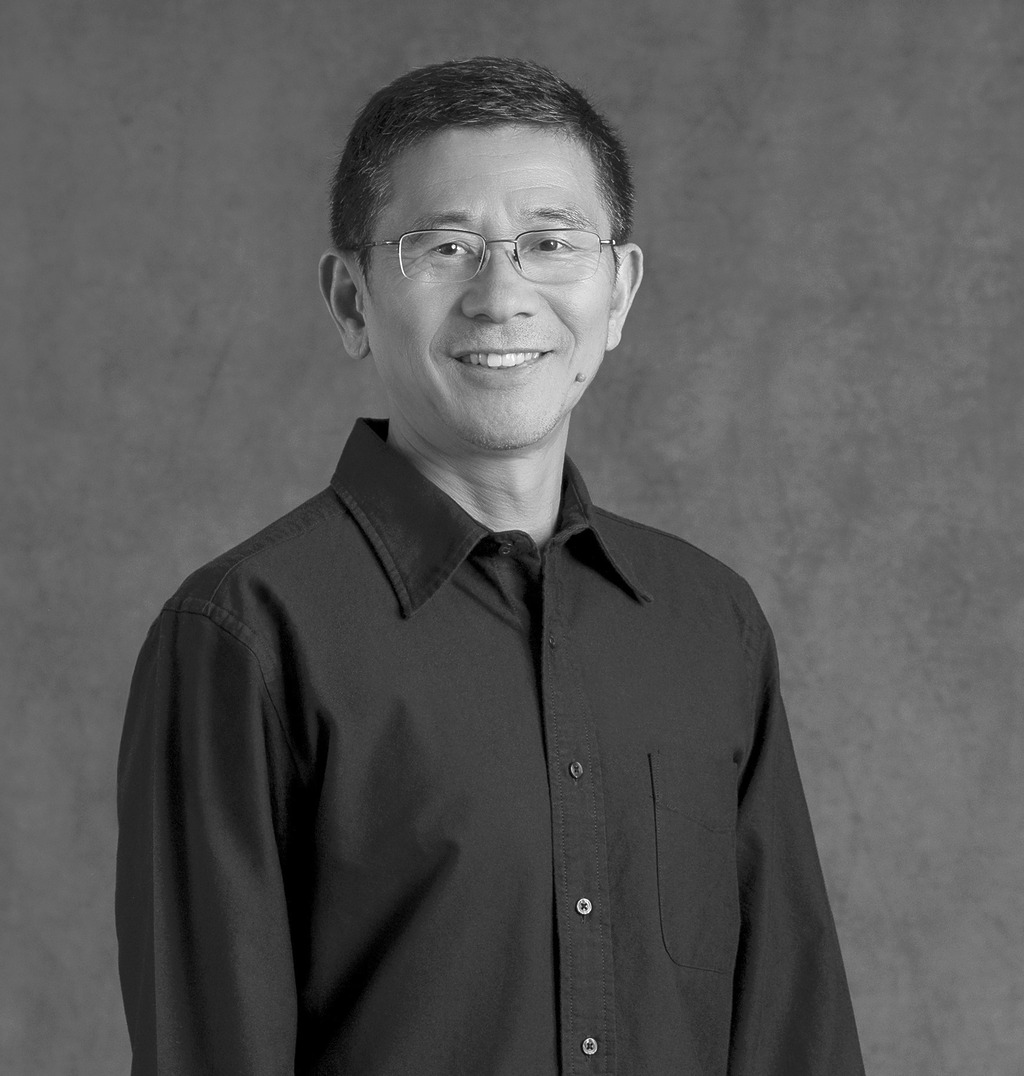Black and white portrait of Robert Zheng, WATG, smiling against a grey backdrop.