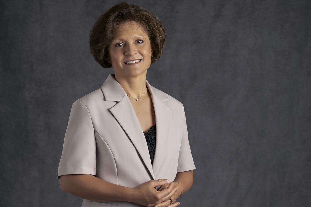 Portrait of Sandra Whipp, WATG, smiling against a grey backdrop.