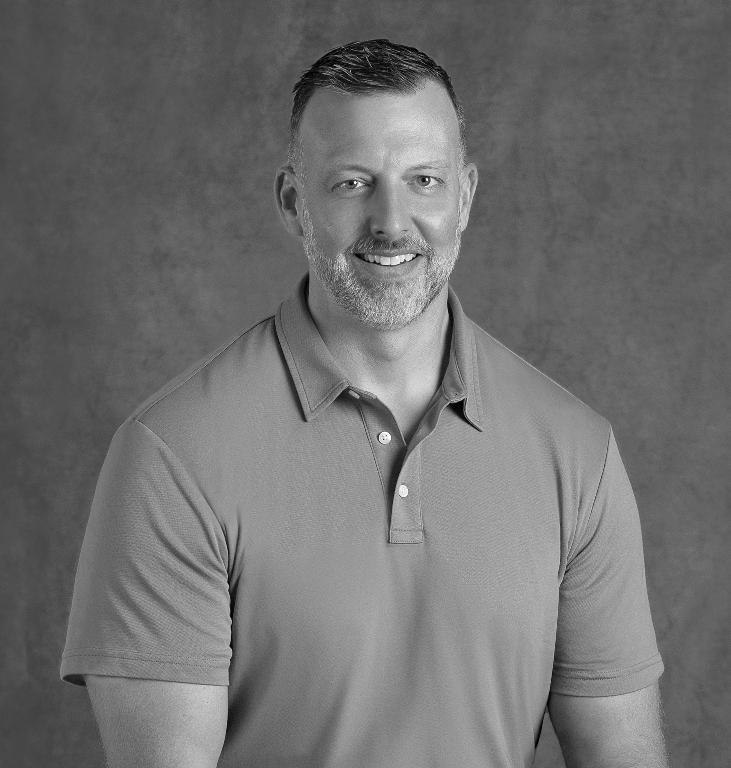 Black and white portrait of Sean Harry, WATG, smiling against a grey backdrop.