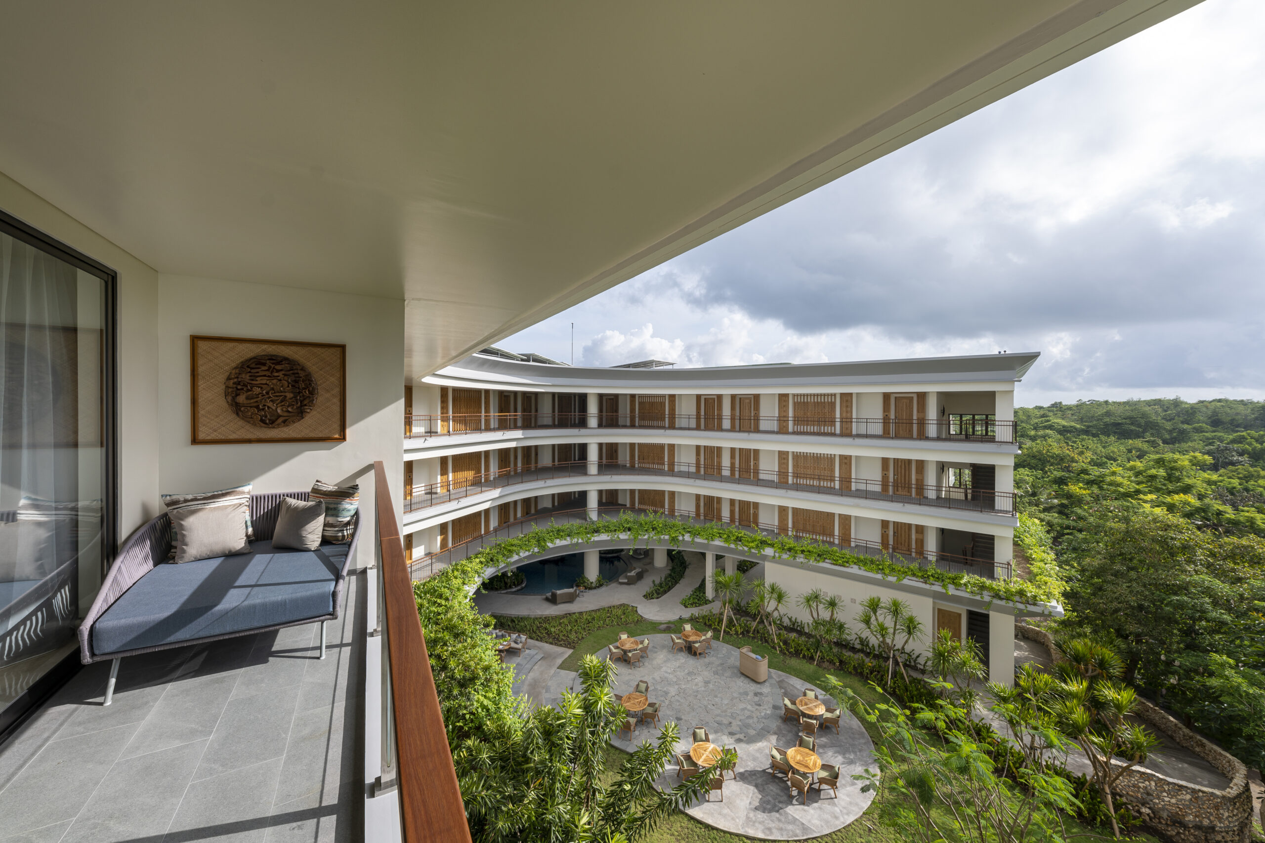 looking over the landscape and architecture from a guestroom balcony at ayana segara bali