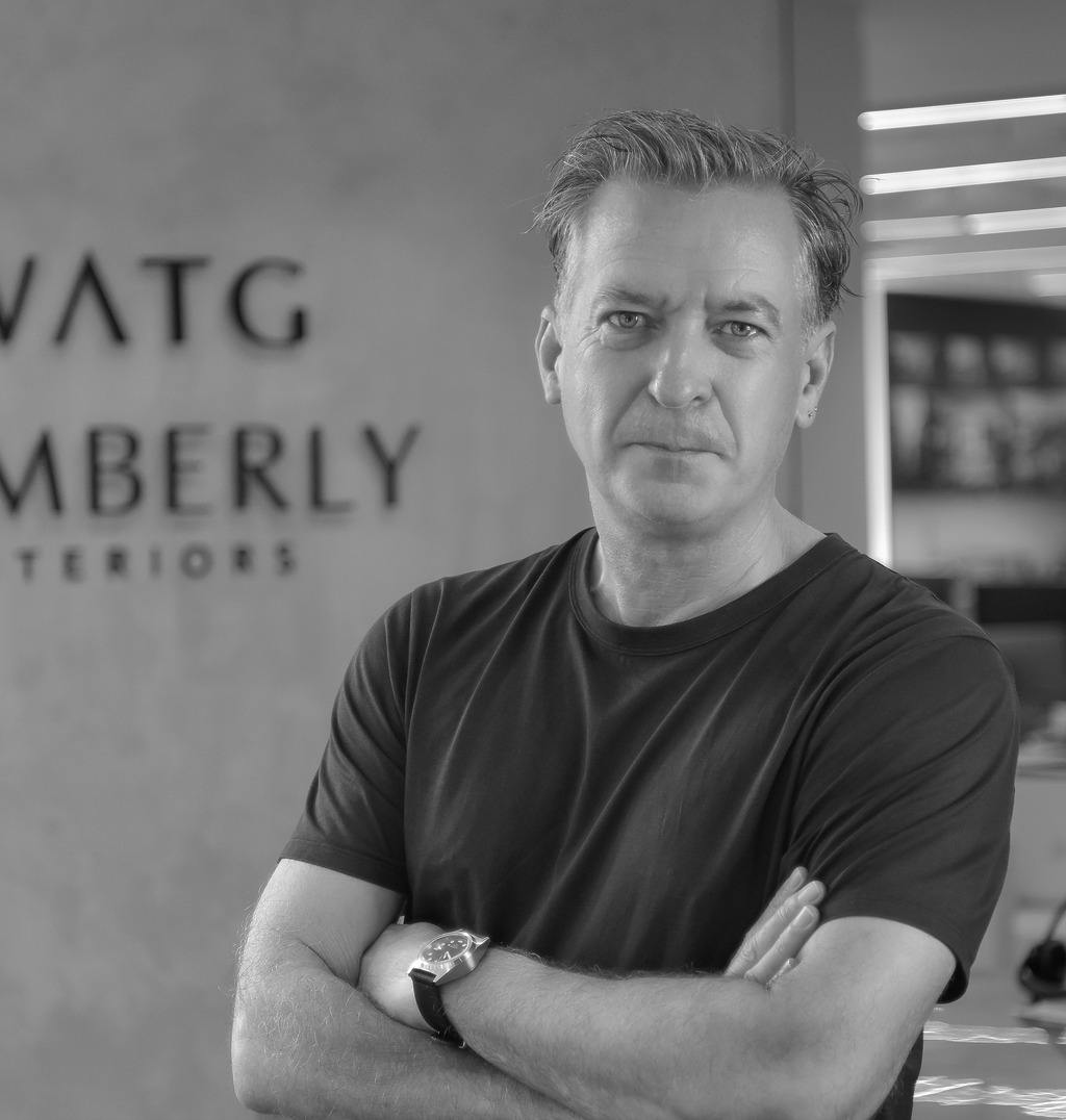 Black and white portrait of Ian Simpson, WATG, smiling against a grey backdrop.