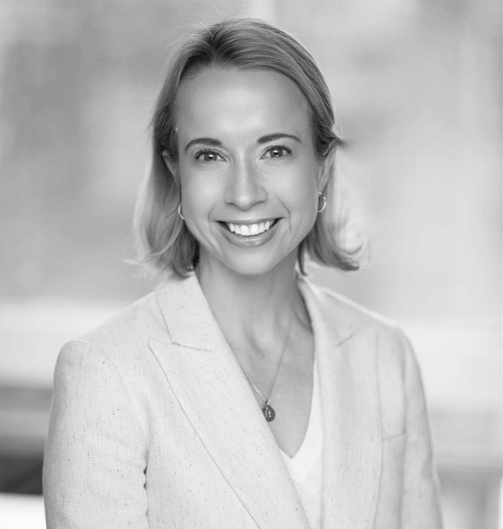 Black and white portrait of Liana Hawes Young, Wimberly Interiors, smiling against a grey backdrop.