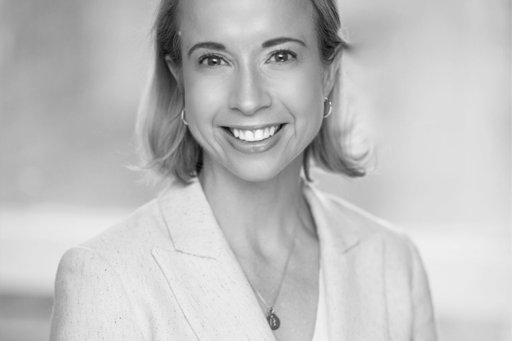 Black and white portrait of Liana Hawes Young, Wimberly Interiors, smiling against a grey backdrop.