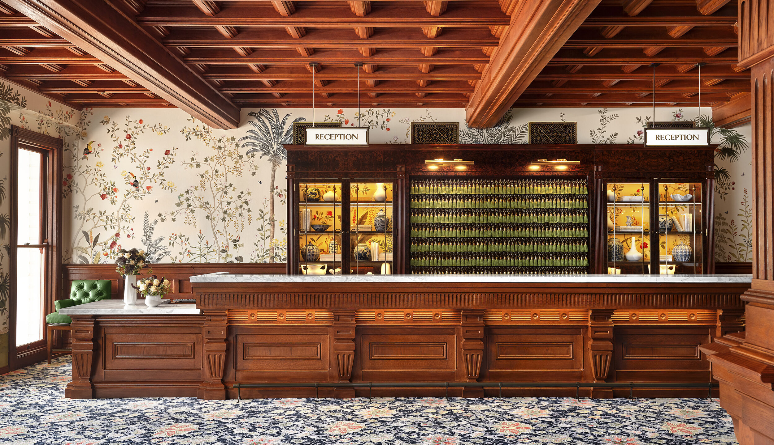 hotel del doronado lobby and reception area, looking toward desk with floral wallpaper and tassel keyrings. integrated design.