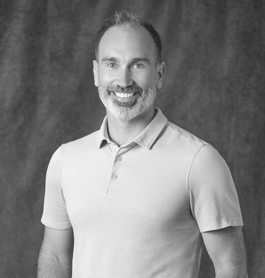 Black and white portrait of Toby Kyle, Associate Principal, Landscape, WATG, smiling against a grey backdrop.