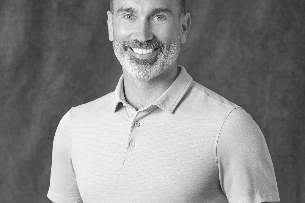 Black and white portrait of Toby Kyle, Associate Principal, Landscape, WATG, smiling against a grey backdrop.
