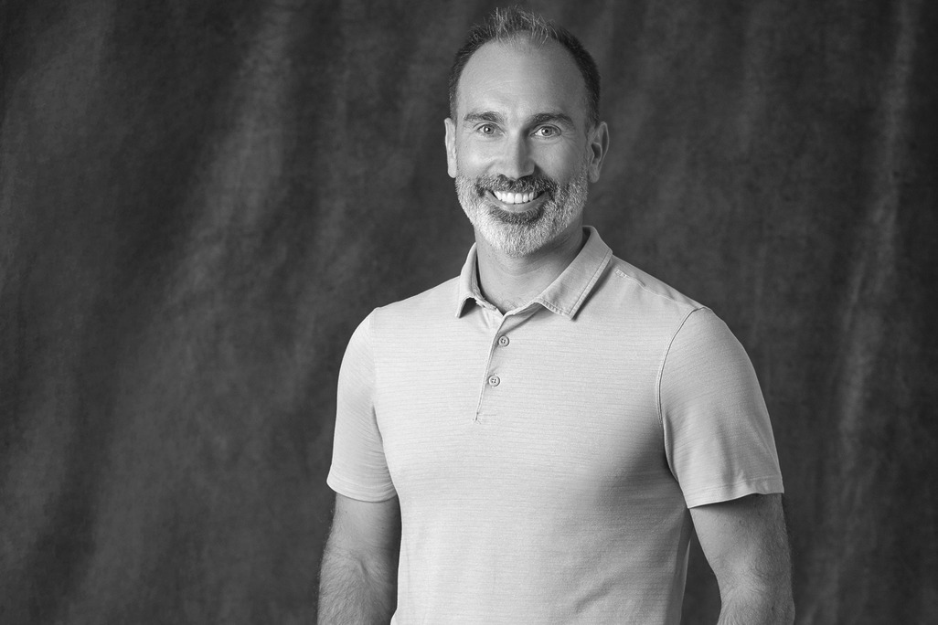 Black and white portrait of Toby Kyle, Associate Principal, Landscape, WATG, smiling against a grey backdrop.