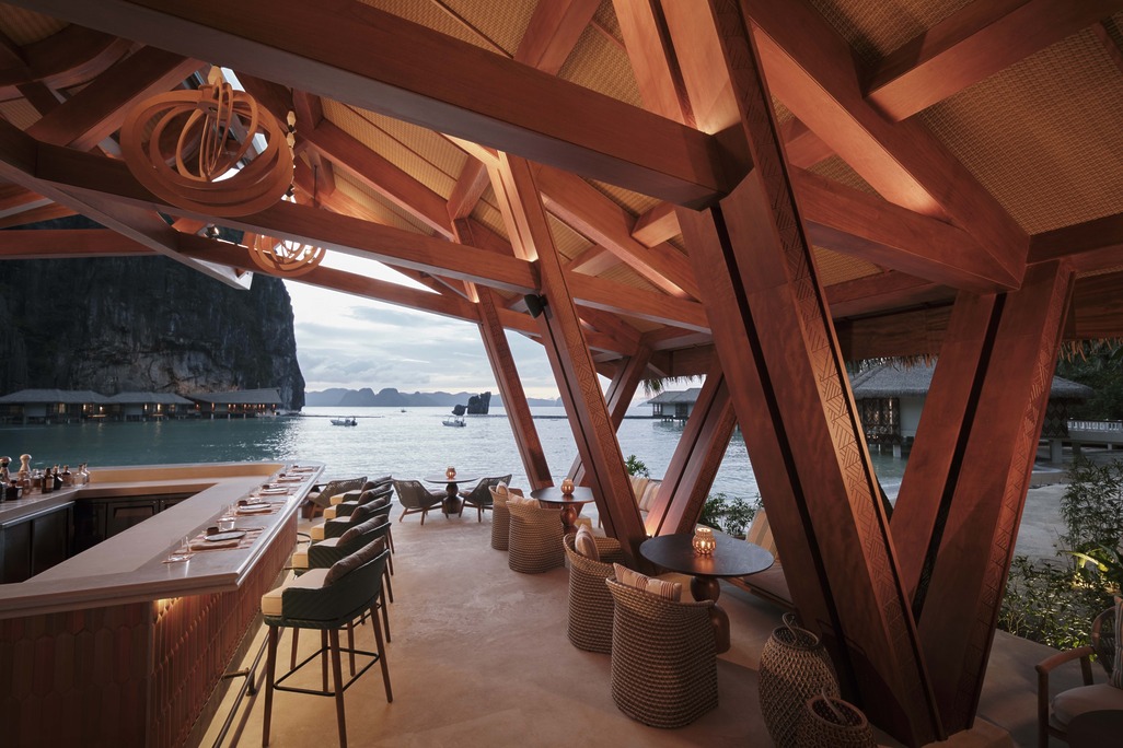 The beach bar at Lagen El Nido features dramatic timber framing and woven textures, offering guests an open-air panoramic view of the Bacuit Bay karst formations.