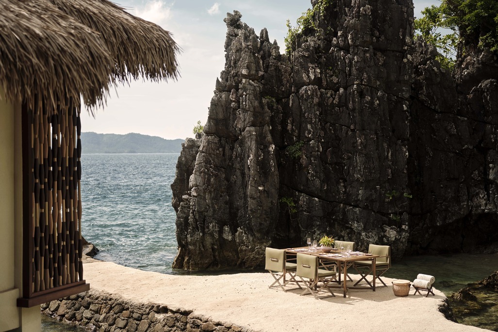 A private alfresco dining setup on a stone outcrop, illustrating the resort's ability to create intimate, luxury moments within the raw limestone geography.