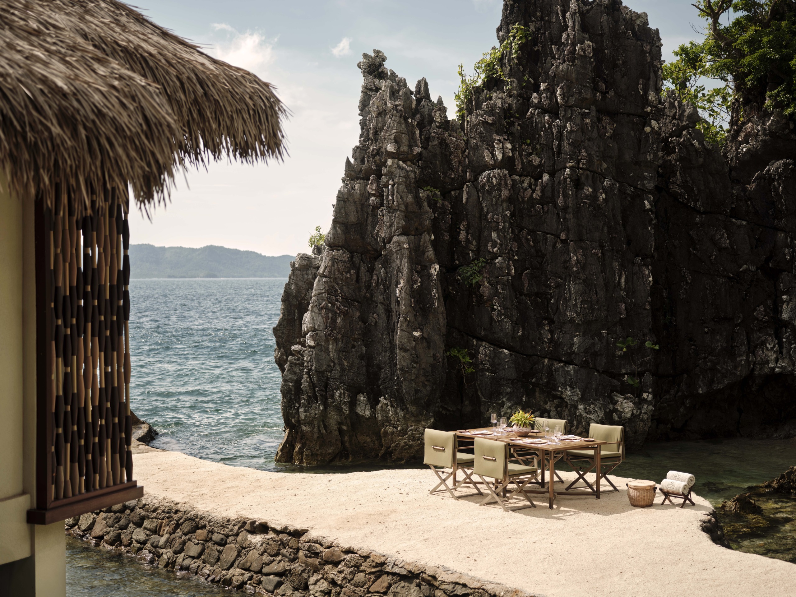 A private alfresco dining setup on a stone outcrop, illustrating the resort's ability to create intimate, luxury moments within the raw limestone geography.