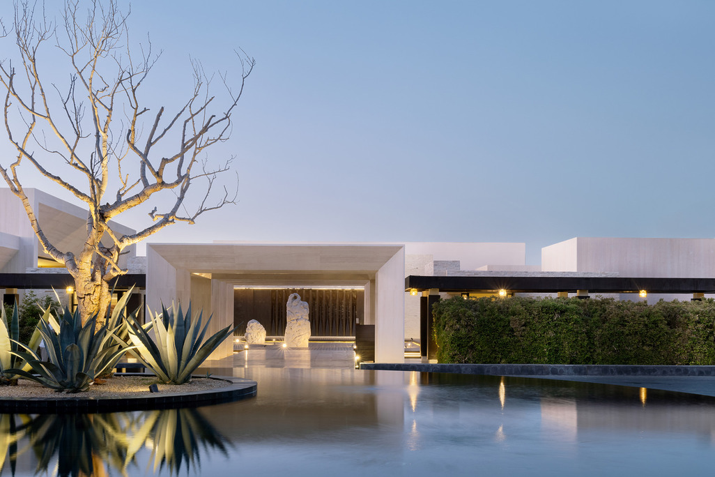 Nobu Hotel Los Cabos entrance with reflecting pool, agave plants, and modern minimalist architecture at sunset