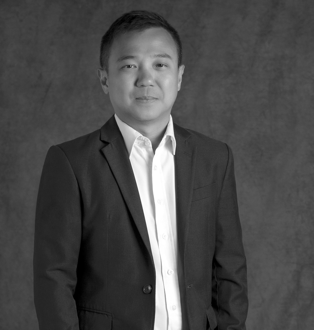 Portrait of Kit Hung Lee, Associate Principal, WATG, standing against a grey backdrop.