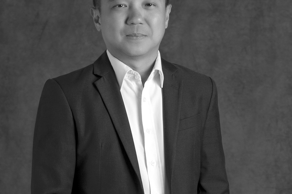 Portrait of Kit Hung Lee, Associate Principal, WATG, standing against a grey backdrop.