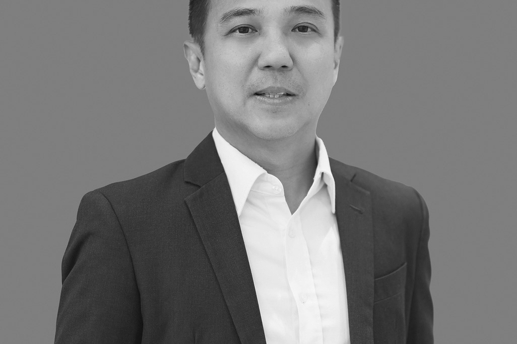 Portrait of Kit Hung Lee, Associate Principal, WATG, standing against a grey backdrop.