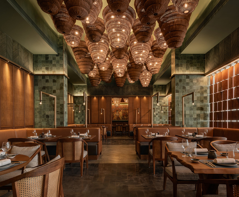 Onu Restaurant by Wimberly F&B, dining room with a dramatic ceiling installation of clustered woven basket pendants above leather banquettes, cane chairs, and zellige-tiled walls.