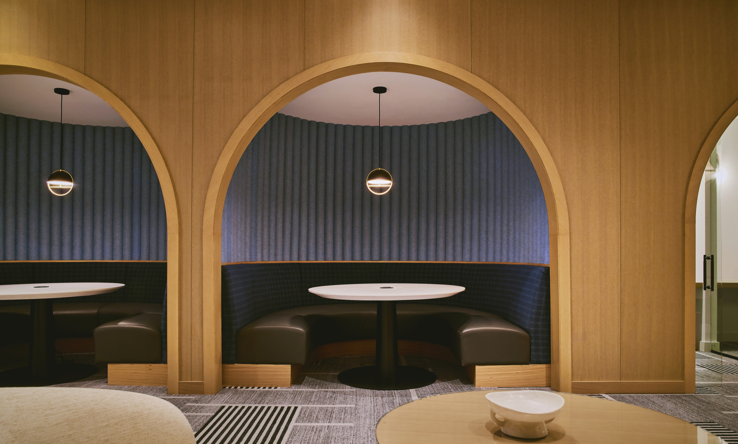 Ski Club lounge featuring dramatic arched timber doorways, pendant lighting, and intimate seating areas at Limelight Hotel Mammoth Lakes, designed by WATG