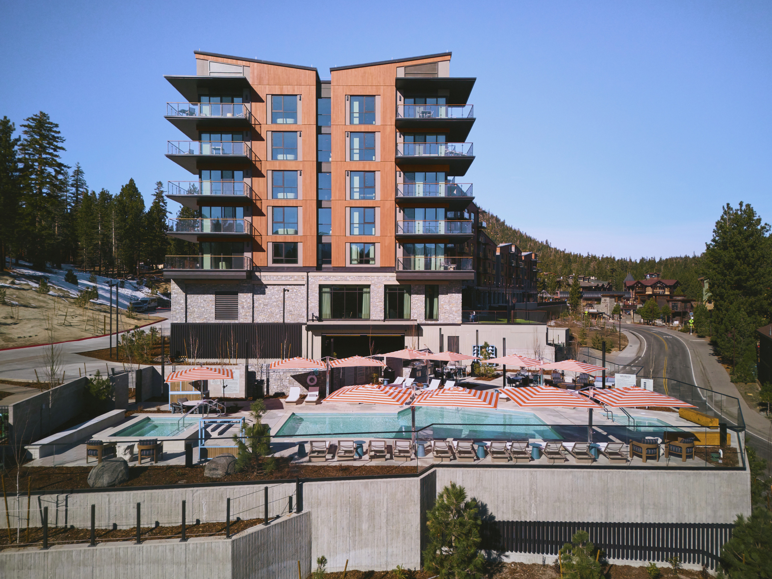 Street-level exterior of Limelight Hotel Mammoth Lakes with contemporary façade, snow-covered surrounds, and mountain backdrop, designed by WATG