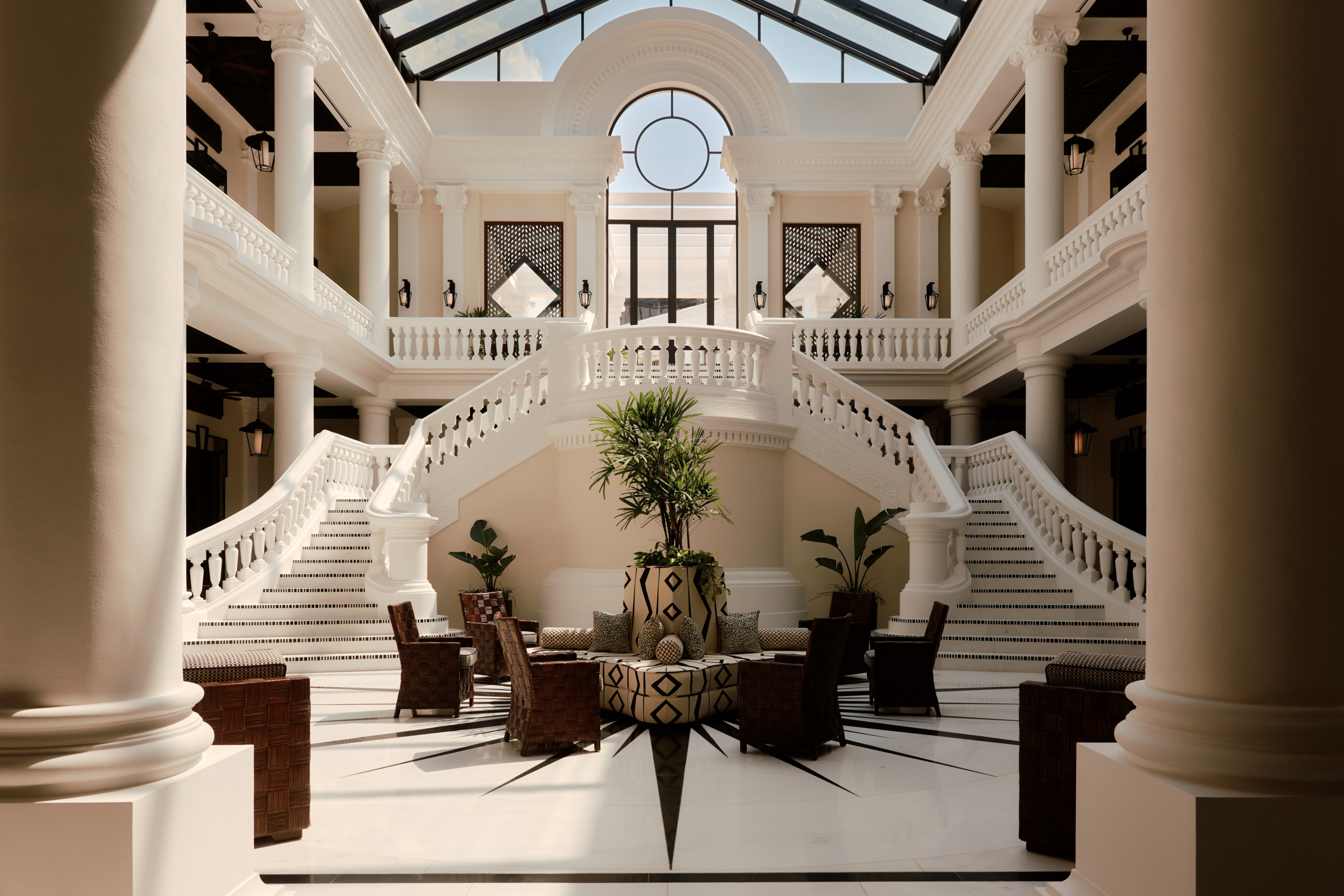 Grand atrium lobby at Four Seasons Cartagena featuring sweeping staircases and skylit ceiling