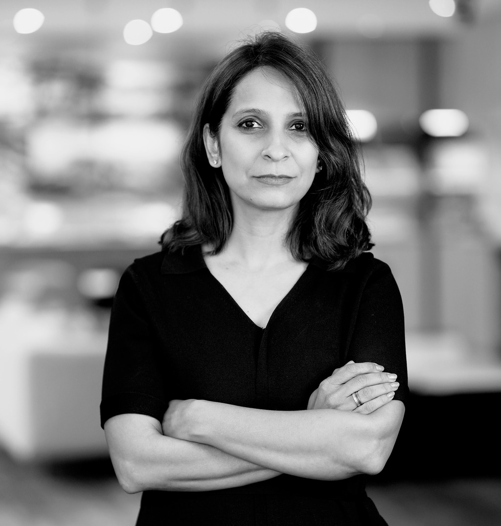 Black and white portrait of Bhavya Kukrety, WATG, smiling against a grey backdrop.