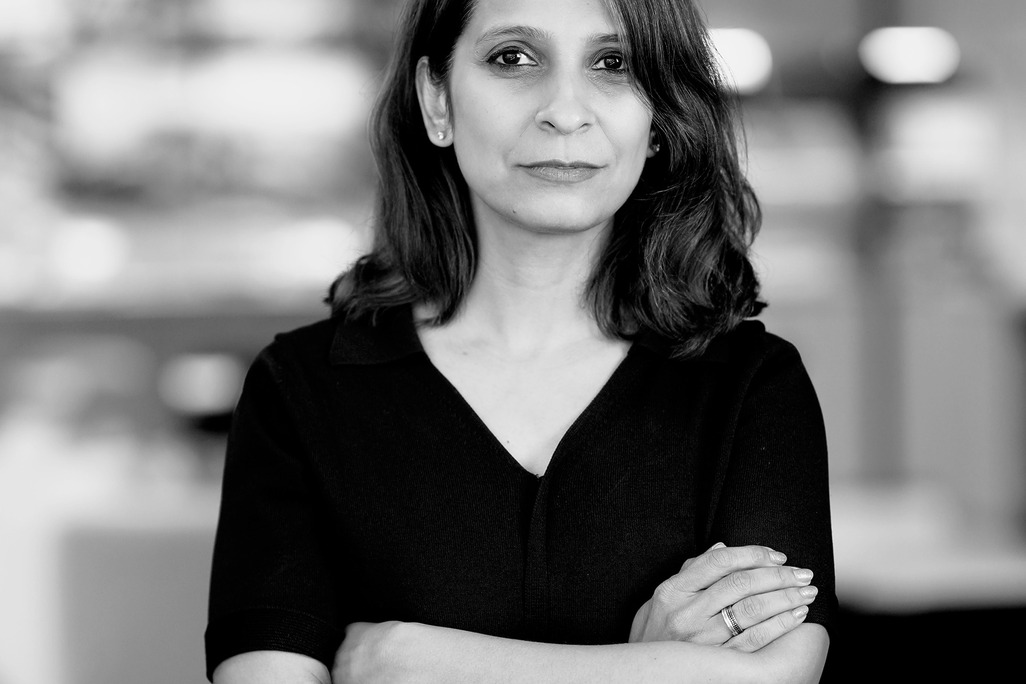 Black and white portrait of Bhavya Kukrety, WATG, smiling against a grey backdrop.