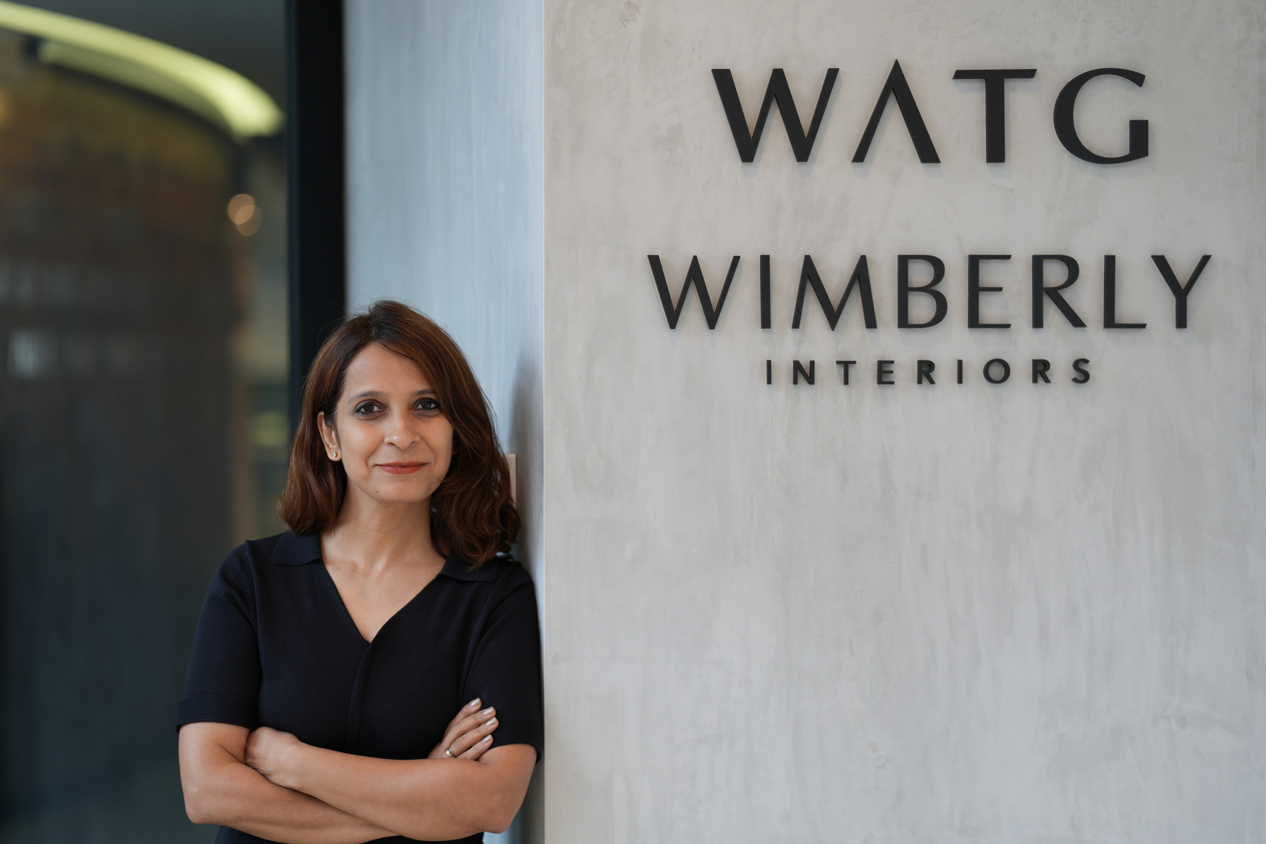 Bhavya Kukrety, newly appointed Managing Director, Asia Pacific at WATG and Wimberly Interiors, standing beside the company signage.