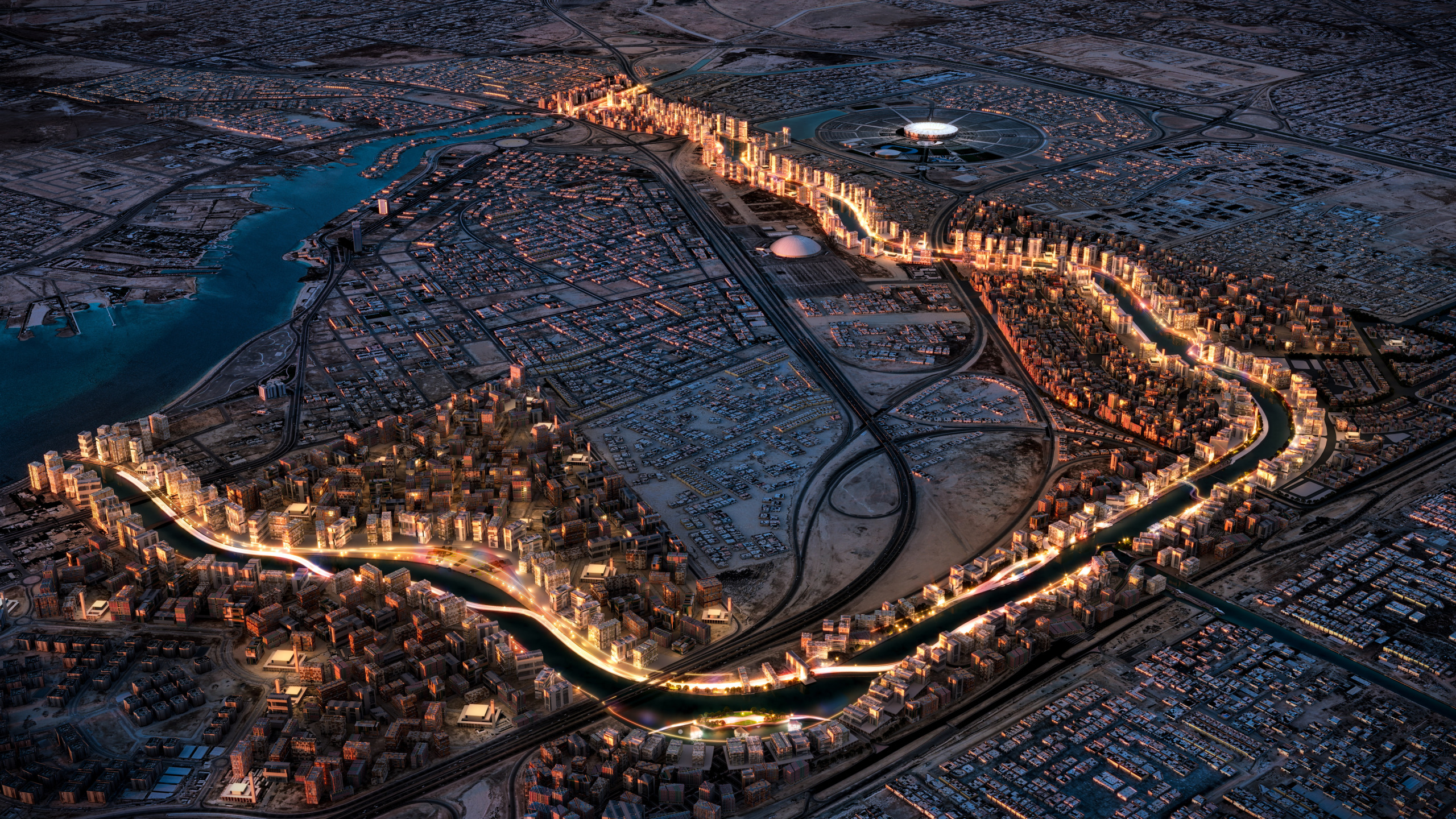 Aerial night view of Marafy waterfront development in Jeddah, Saudi Arabia, showing an illuminated canal winding through dense mixed-use buildings, with a circular stadium and open desert landscape in the background.