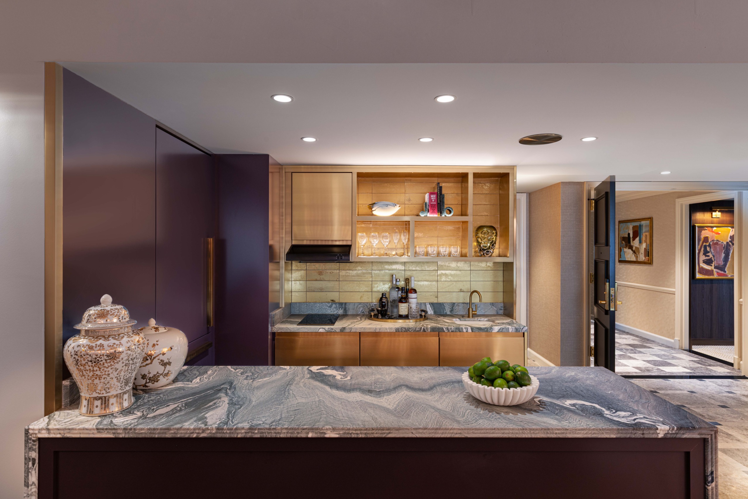 Open kitchen with marbled island, bronze cabinetry, and glassware bar shelving, Promenade Suite, JW Marriott Essex House.