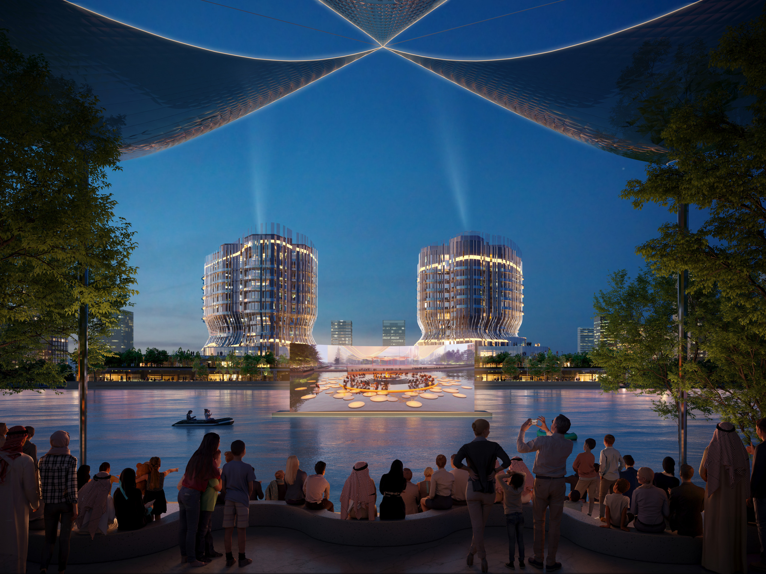 Nighttime rendering of two illuminated twin towers on a waterfront, with crowds gathered on the shoreline watching a large screen displaying a performance on a floating stage.