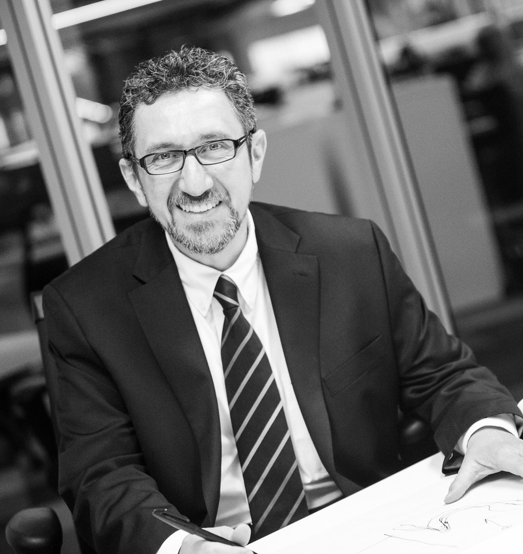 Black and white photo of Ala Hanson, Associate Principal and Regional Director of WATG Abu Dhabi, dressed in a suit with an office backdrop.