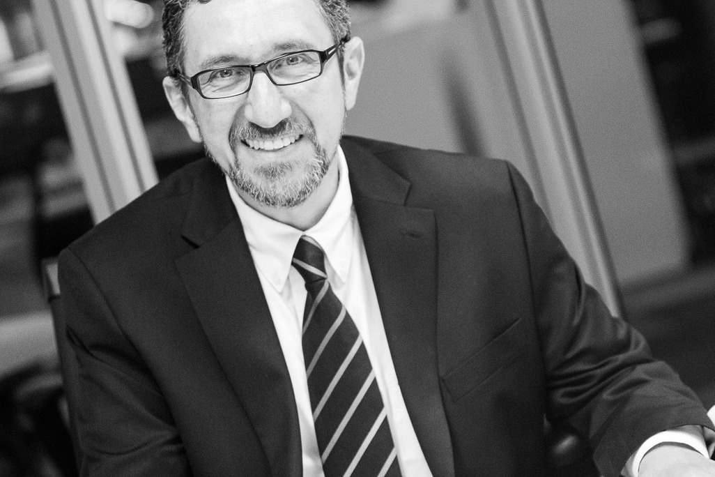 Black and white photo of Ala Hanson, Associate Principal and Regional Director of WATG Abu Dhabi, dressed in a suit with an office backdrop.